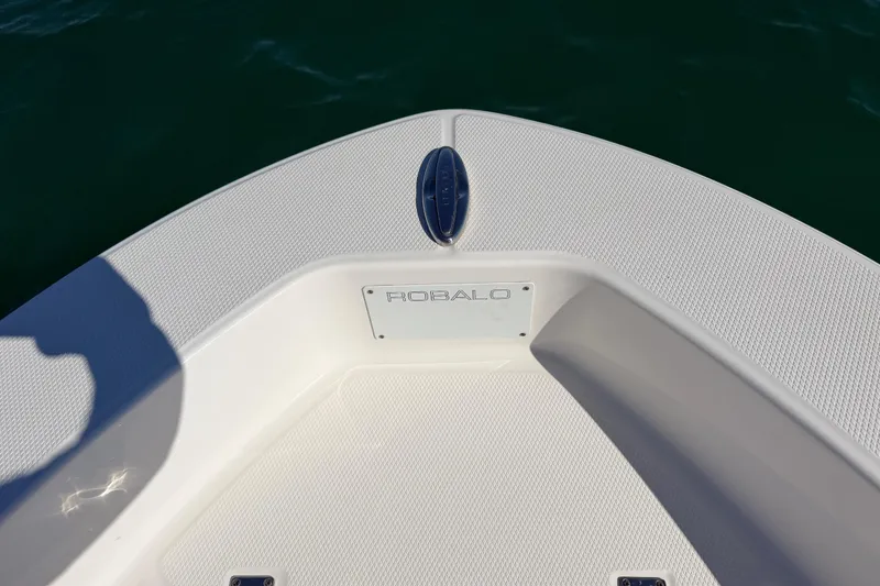 Slide: The Image of 2020 Robalo R160 Center Console boat deck with logo, on calm water. - 16