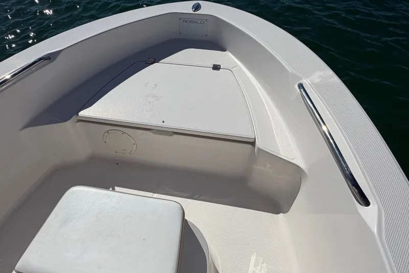 Slide: The Image of 2020 Robalo R160 Center Console boat interior with seating and storage, on water. - 38