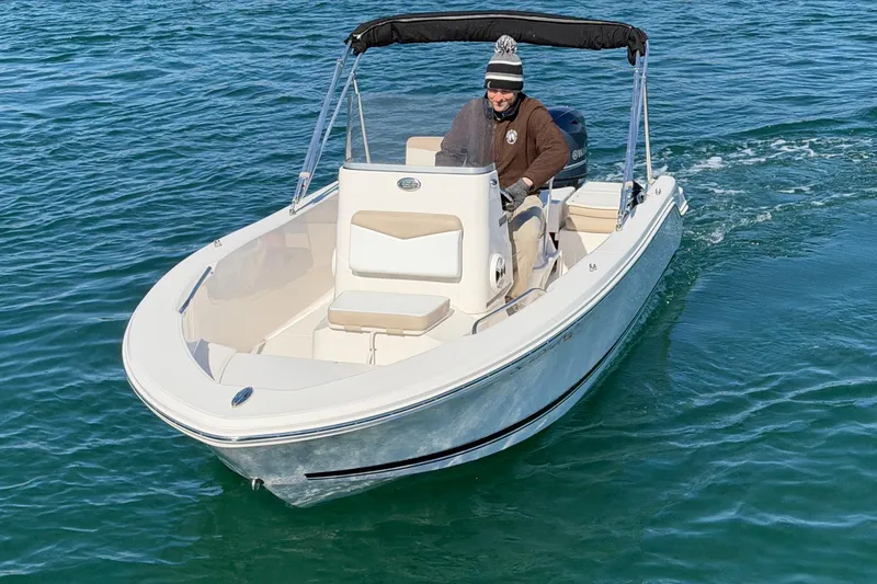 Slide: The Image of 2020 Robalo R160 Center Console boat cruising on clear blue water. - 4