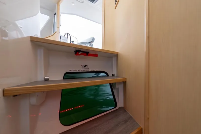 Slide: The Image of Interior view of 2026 Seawind 1160XL yacht, featuring wooden steps and an emergency escape panel. - 15