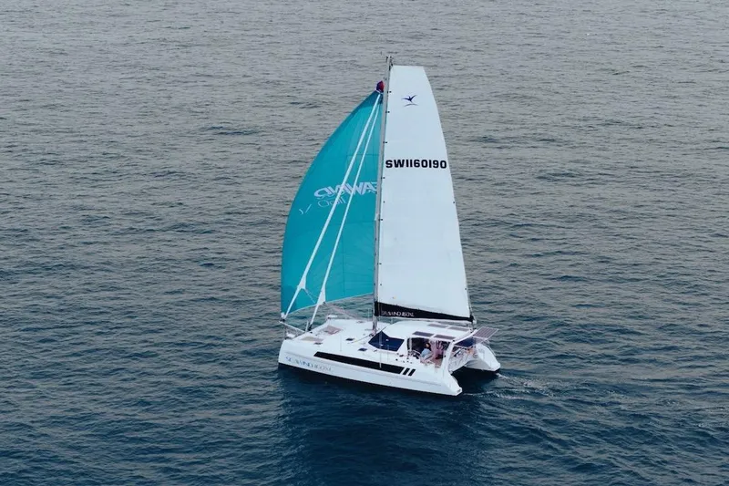 Slide: The Image of 2026 Seawind 1160XL catamaran sailing on open ocean with turquoise and white sails. - 3