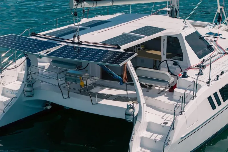 Slide: The Image of 2026 Seawind 1160XL catamaran with solar panels on deck, sailing in clear blue waters. - 4