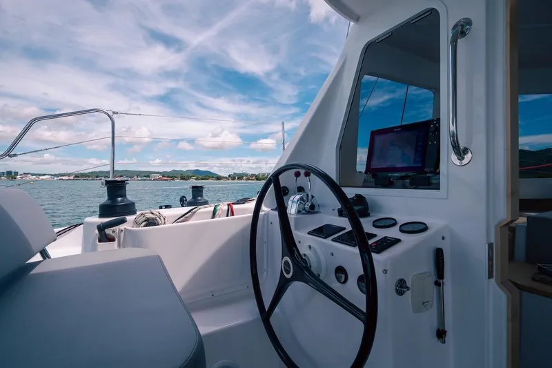Slide: The Image of Helm of 2026 Seawind 1160XL catamaran with navigation equipment, overlooking scenic waters. - 8
