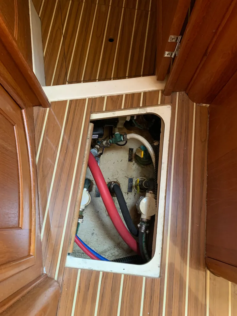 Slide: The Image of Floor hatch of a 2007 Hunter 41 sailboat showing plumbing. - 49
