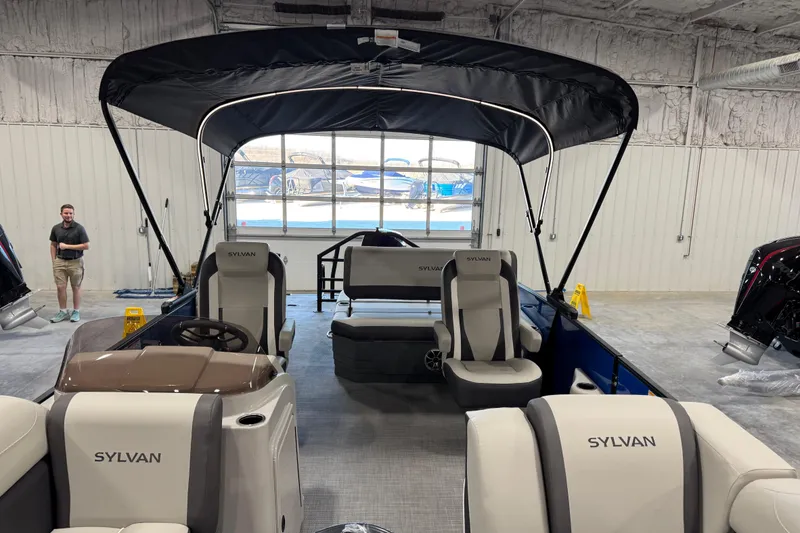 Slide: The Image of 2026 Sylvan X 5 boat interior with canopy, displayed in a showroom. - 12