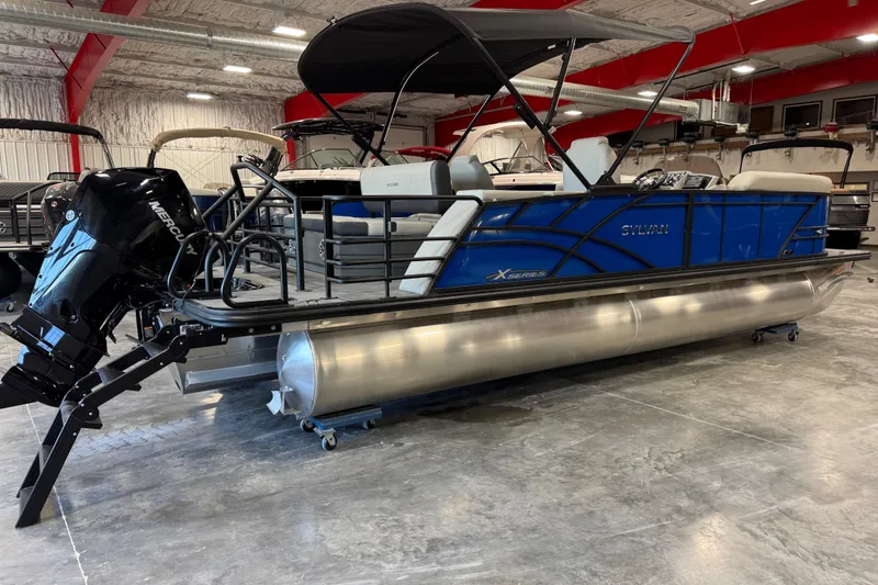 Slide: The Image of 2026 Sylvan X 5 pontoon boat with Mercury engine in showroom. - 3