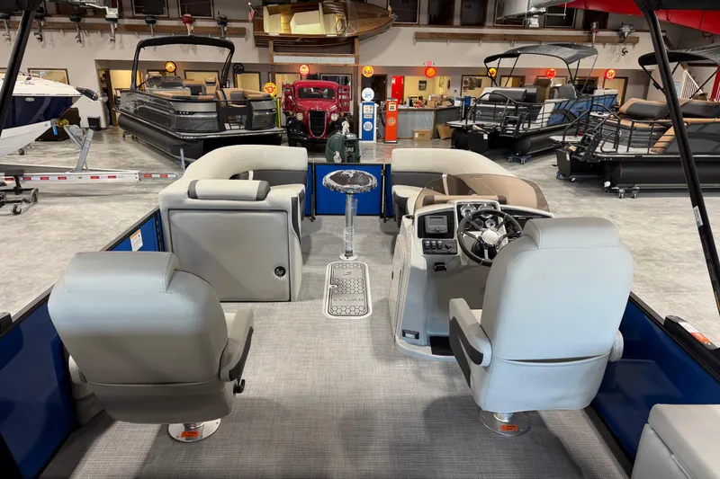Slide: The Image of Interior view of 2026 Sylvan X 5 boat in showroom, featuring modern seating and control panel. - 7