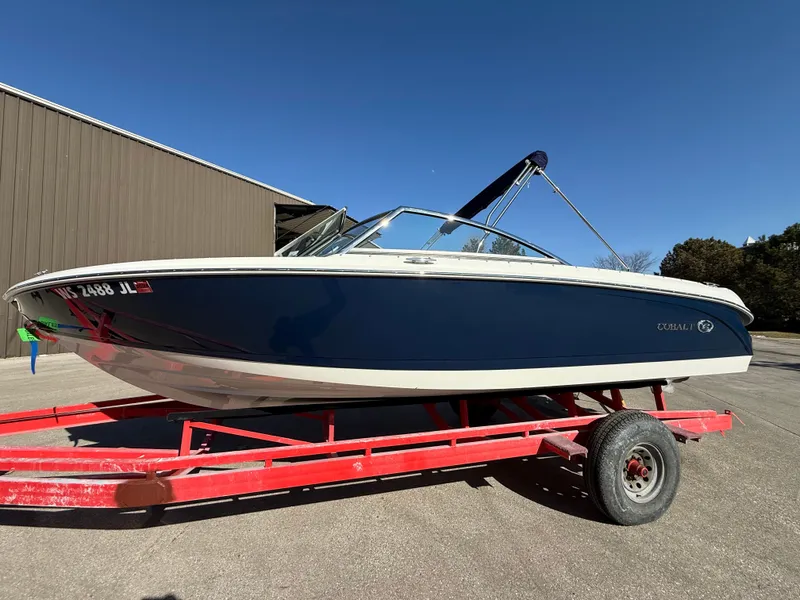 Slide: The Image of 2015 Cobalt 220S boat on red trailer, blue sky. - 1