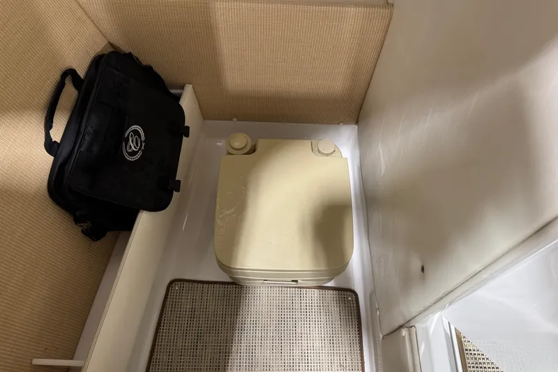 Slide: The Image of Compact bathroom space in a 2015 Cobalt R5 boat with portable toilet and black bag. - 13