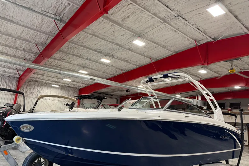 Slide: The Image of 2015 Cobalt R5 boat in a warehouse with red beams and bright lighting. - 3