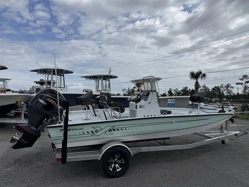 Slide: The Image of 2026 Xpress H20B Bay boat on trailer under cloudy sky. - 1