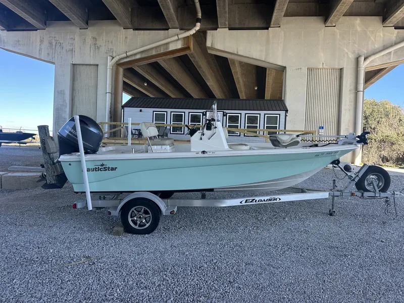 Slide: The Image of 2018 NauticStar 1810 NauticBay boat on trailer under bridge. - 1