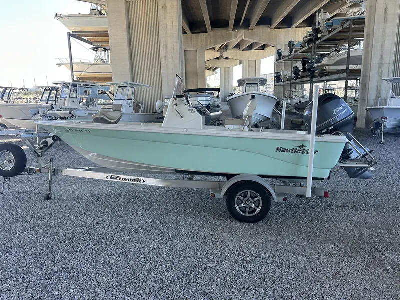 Slide: The Image of 2018 NauticStar 1810 NauticBay boat on trailer under bridge. - 8