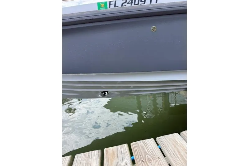 Slide: The Image of 2024 Axopar 37 Sun-Top boat hull near dock, Florida registration visible. - 24