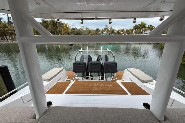 Slide: The Image of 2024 Axopar 37 Sun-Top boat interior with seating, overlooking a serene waterway. - 4