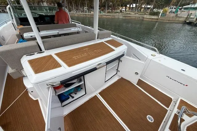 Slide: The Image of 2024 Axopar 37 Sun-Top boat interior with teak flooring and storage compartments. - 7