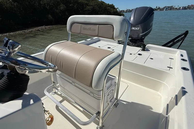 Slide: The Image of 2012 ShearWater 25 LTZ boat interior with seating and motor, on calm water. - 11