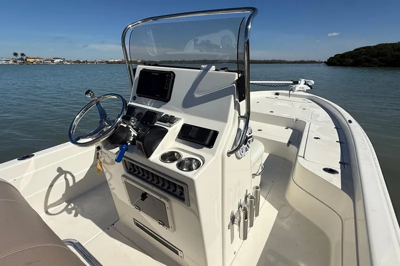 Slide: The Image of 2012 ShearWater 25 LTZ boat console with steering wheel and navigation system on calm water. - 13