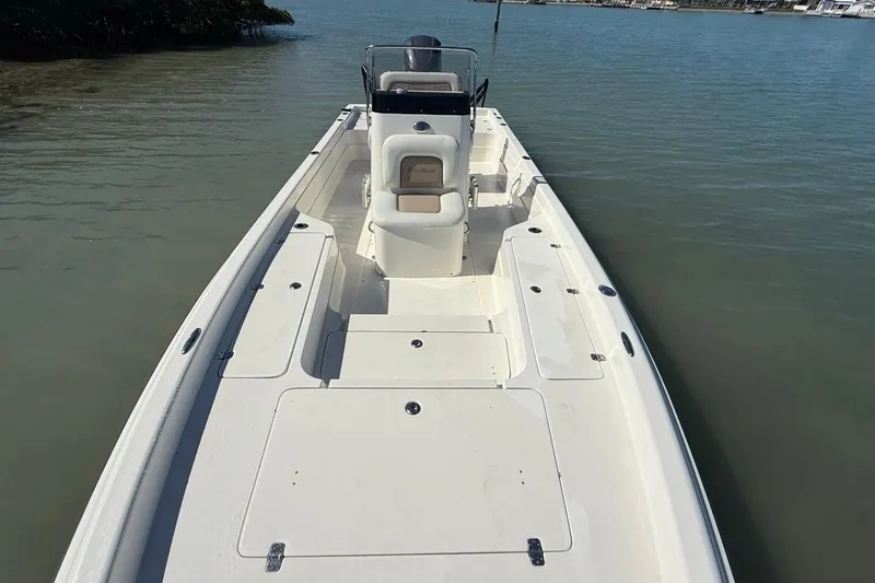 Slide: The Image of 2012 ShearWater 25 LTZ boat on calm water, showcasing spacious deck layout. - 15