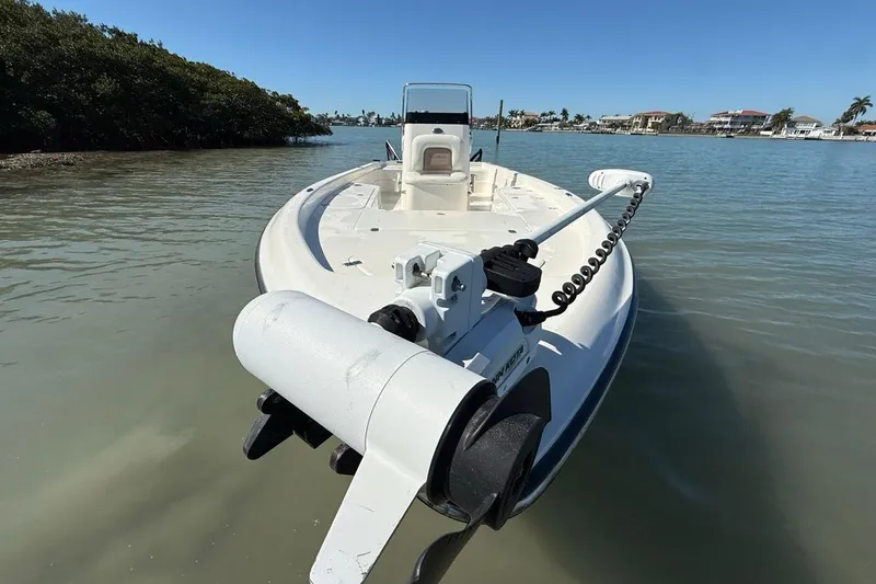Slide: The Image of 2012 ShearWater 25 LTZ boat on calm water, featuring a trolling motor. - 16