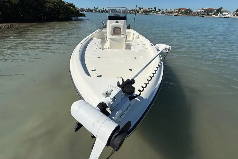 Slide: The Image of 2012 ShearWater 25 LTZ boat on calm water, showcasing sleek design and trolling motor. - 17