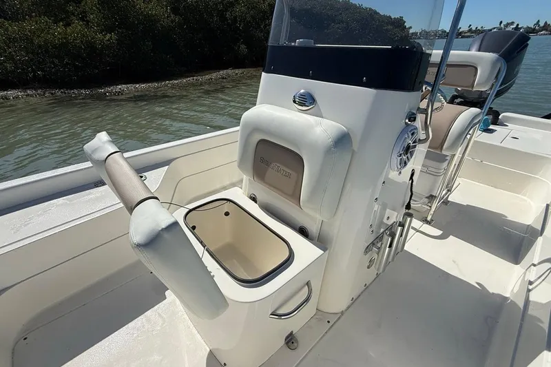 Slide: The Image of 2012 ShearWater 25 LTZ boat interior with seating and storage, on calm water. - 18