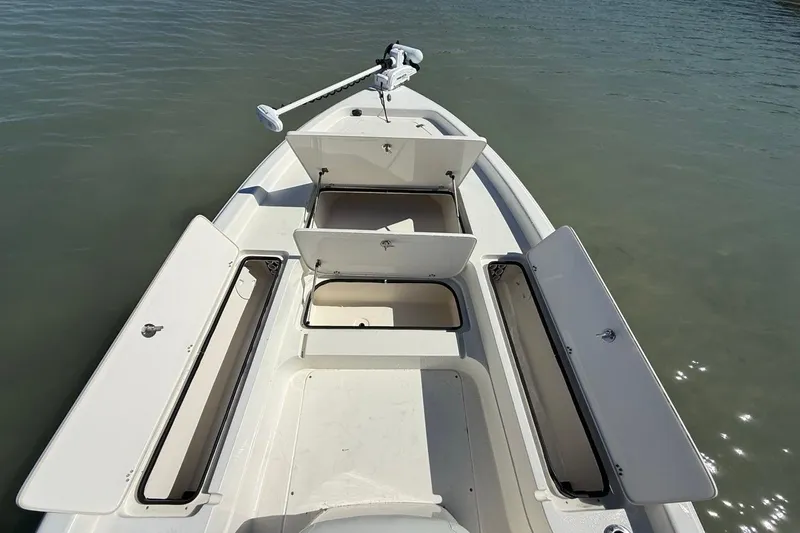 Slide: The Image of 2012 ShearWater 25 LTZ boat with open storage compartments on calm water. - 20