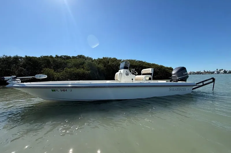 Slide: The Image of 2012 ShearWater 25 LTZ boat on calm water, clear sky background. - 5