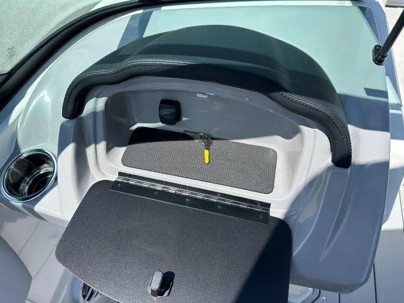 Slide: The Image of Interior of 2026 Chaparral 21 SSi with storage compartment and cup holder. - 21