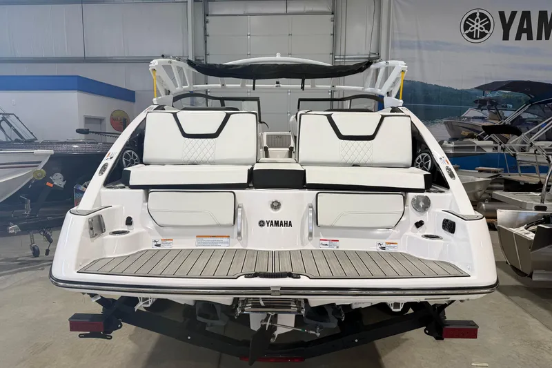 Slide: The Image of 2025 Yamaha Boats 252S, sleek white design, rear view in showroom setting. - 2