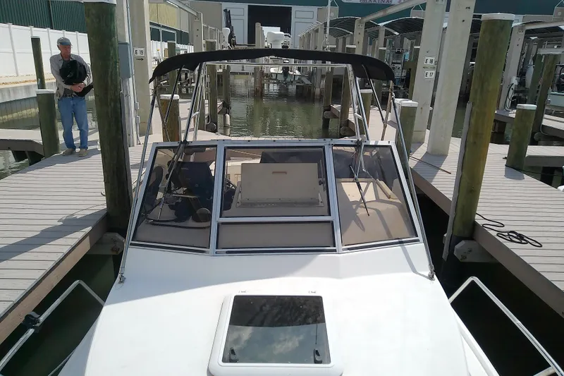 Slide: The Image of 1996 Shamrock 260 Express boat docked at marina with covered cockpit. - 10