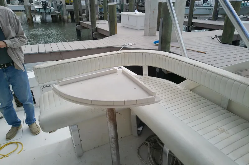 Slide: The Image of 1996 Shamrock 260 Express boat interior with seating and table at a marina. - 16