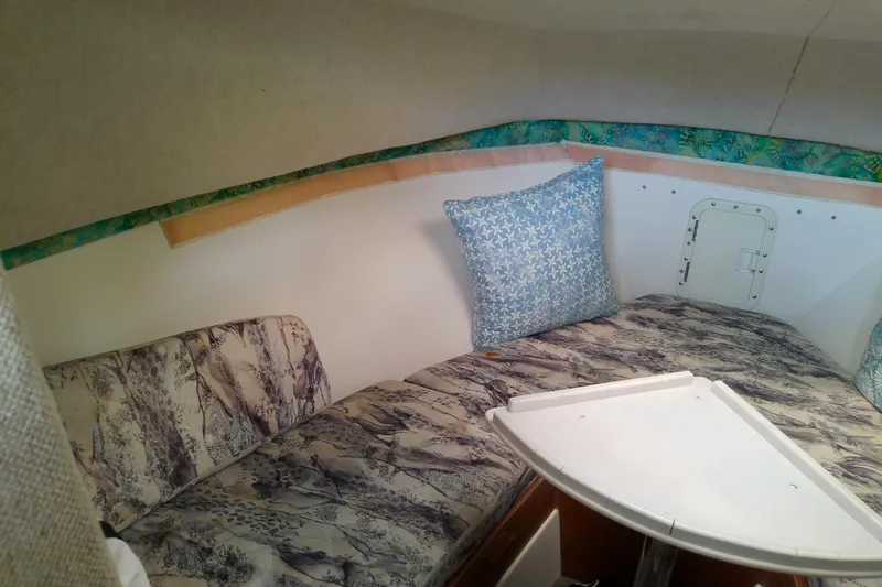 Slide: The Image of 1996 Shamrock 260 Express cabin interior with patterned cushions and pillows. - 24