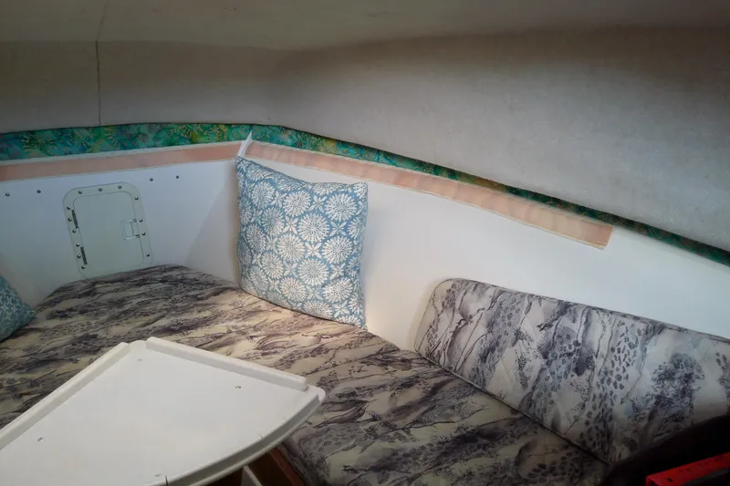 Slide: The Image of Interior cabin of a 1996 Shamrock 260 Express boat with patterned cushions and pillows. - 25
