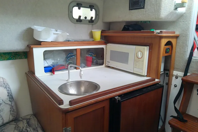 Slide: The Image of 1996 Shamrock 260 Express boat interior with kitchenette, sink, and microwave. - 27
