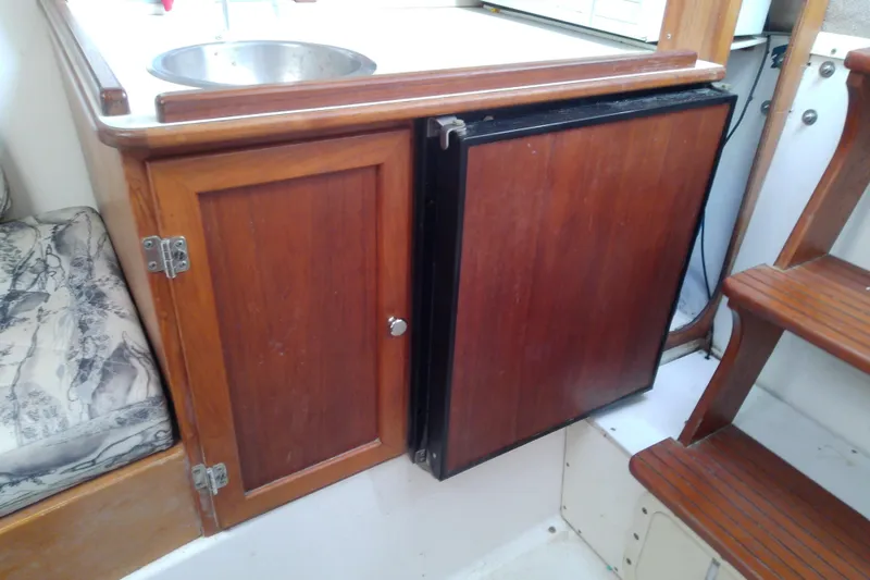 Slide: The Image of 1996 Shamrock 260 Express boat interior with wooden cabinetry and compact sink. - 28