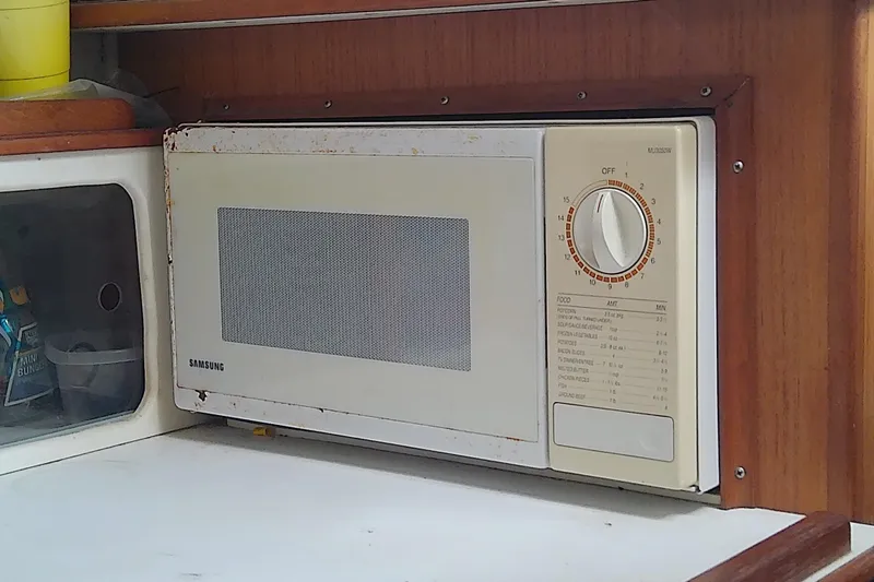 Slide: The Image of 1996 Shamrock 260 Express interior with built-in Samsung microwave in wooden cabinetry. - 30