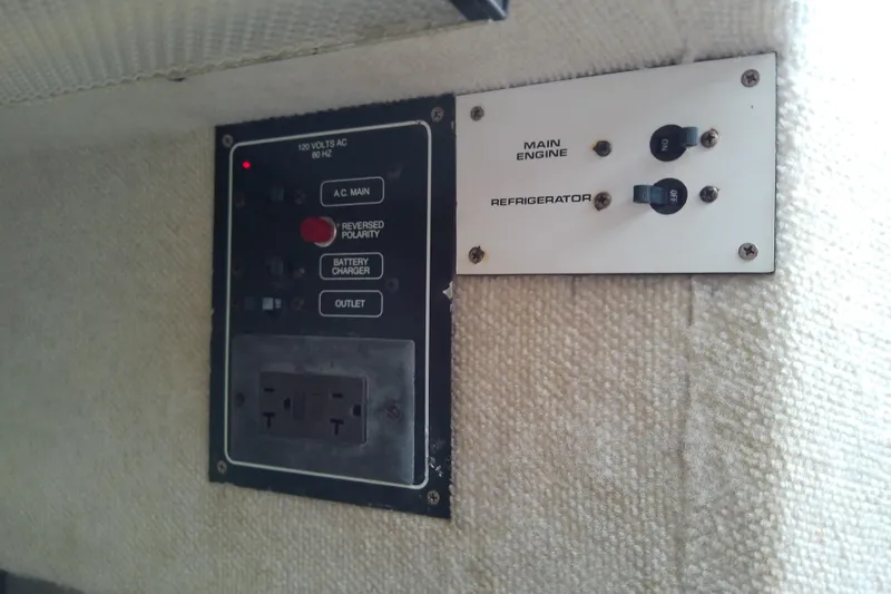 Slide: The Image of Electrical panel of a 1996 Shamrock 260 Express boat, featuring AC controls and switches. - 31