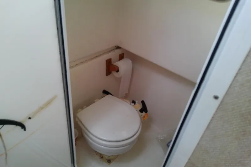 Slide: The Image of 1996 Shamrock 260 Express boat bathroom with toilet and toilet paper holder. - 32