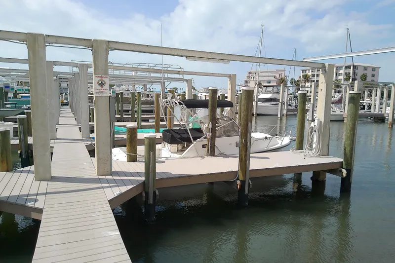 Slide: The Image of 1996 Shamrock 260 Express docked at a marina under a clear sky. - 4