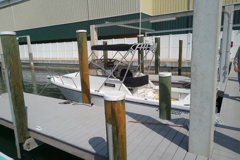 Slide: The Image of 1996 Shamrock 260 Express boat docked at marina with protective canopy. - 6