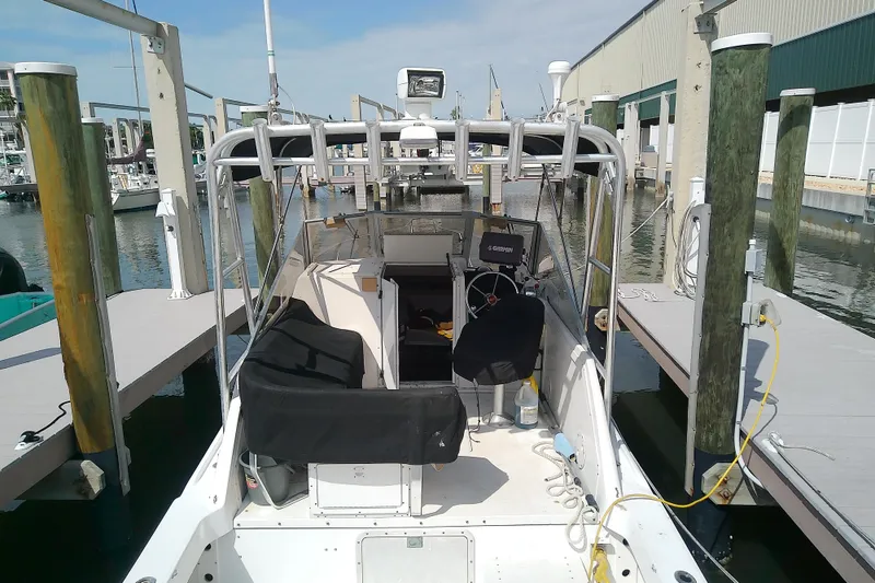 Slide: The Image of 1996 Shamrock 260 Express boat docked at marina, featuring open cockpit and navigation equipment. - 8