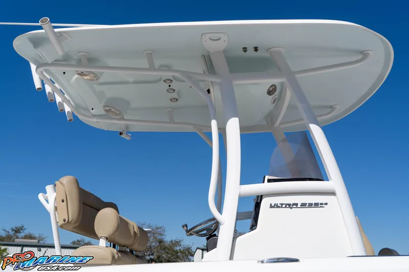 Slide: The Image of 2017 Sea Hunt Ultra 235 SE boat with T-top and seating, under clear blue sky. - 16