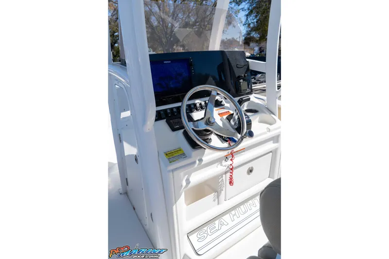 Slide: The Image of 2017 Sea Hunt Ultra 235 SE boat dashboard with steering wheel and navigation controls. - 26
