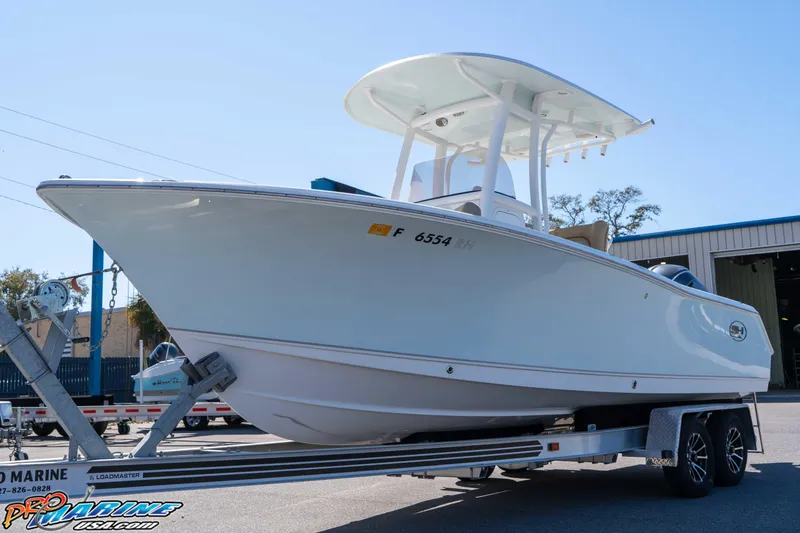 Slide: The Image of 2017 Sea Hunt Ultra 235 SE boat on trailer, displayed outdoors. - 6