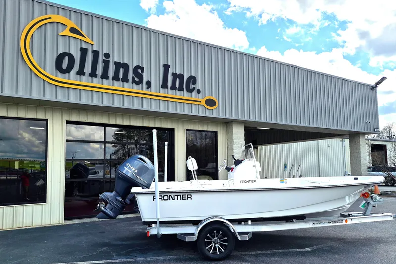 The Image of 2026 Frontier 180 boat on trailer outside Collins Inc. building under blue sky. - 0