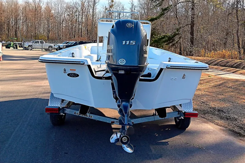 Slide: The Image of 2026 Frontier 180 boat with open deck, parked outdoors under clear blue sky. - 8