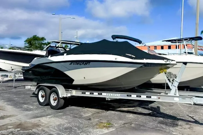 The Image of 2024 Starcraft SVX 211 OB boat on trailer, covered, parked outdoors. - 0