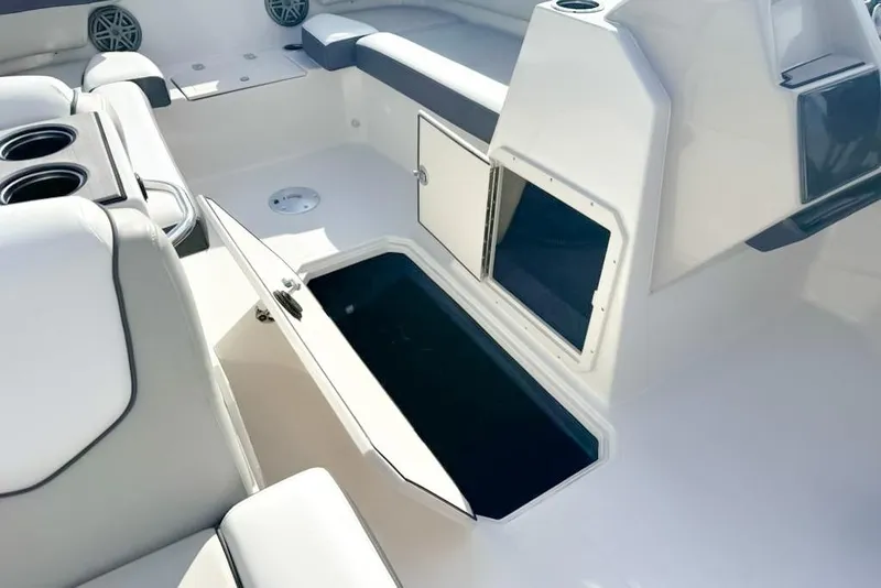 Slide: The Image of 2024 Starcraft SVX 211 OB boat interior with open storage compartments and cup holders. - 5