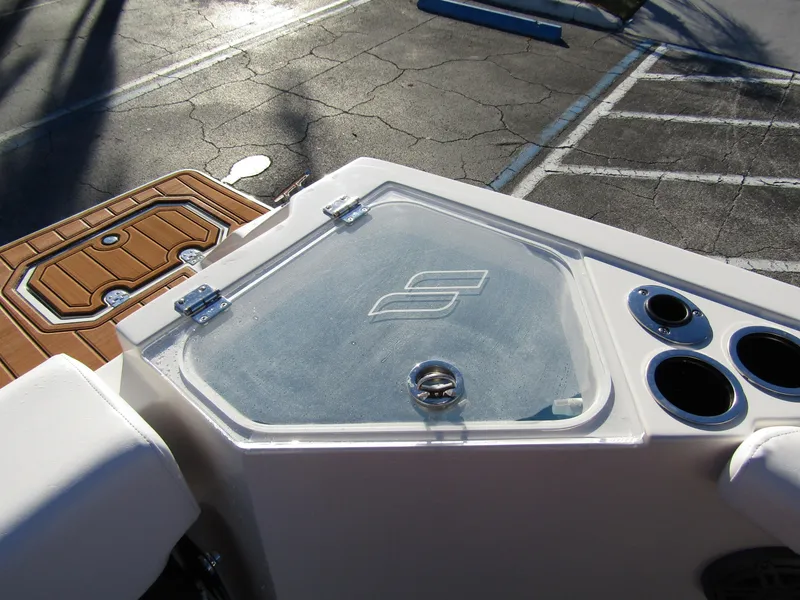 Slide: The Image of 2024 Starcraft SVX 231 OB CC boat deck with storage compartment and cup holders. - 26